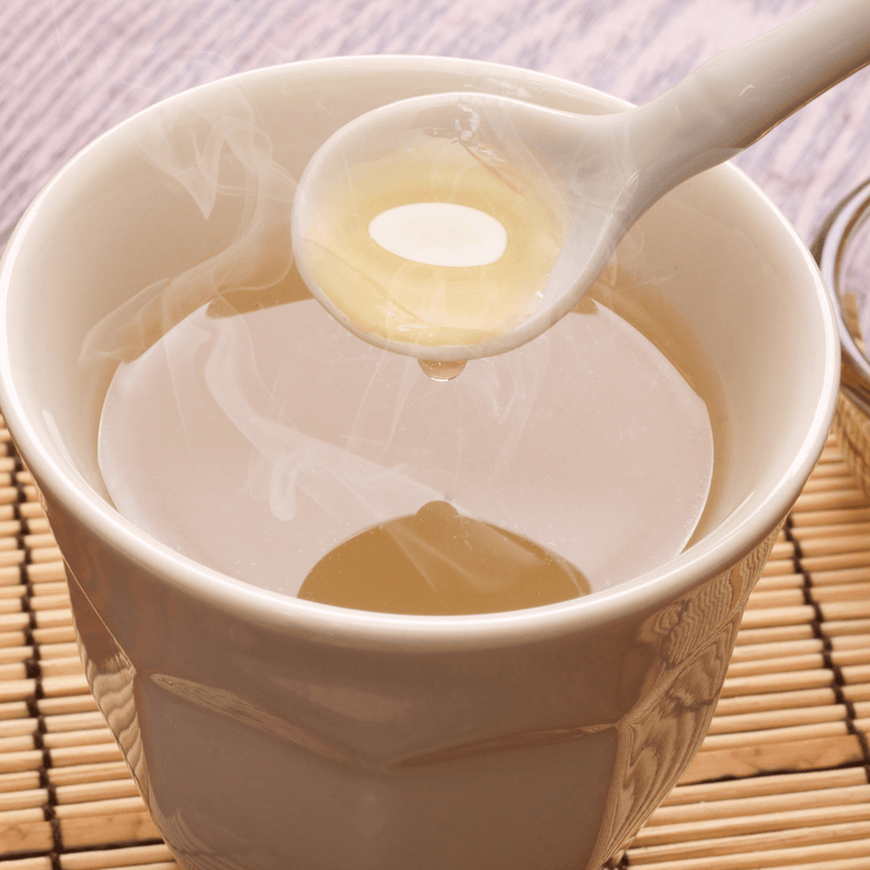 A steaming cup of Manuka tea with a spoon, featured in The Ultimate Guide to Avoiding Hot Water Soaking with Manuka.