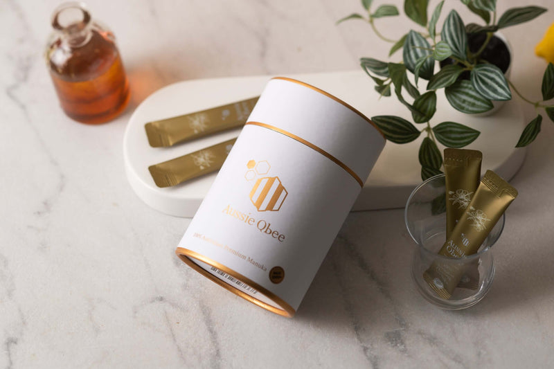 What is the mgo grade of manuka honey product with packaging and honey jar on a marble surface.