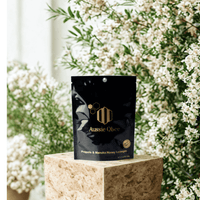Aussie Qbee product packaging on a stone pedestal with a floral background