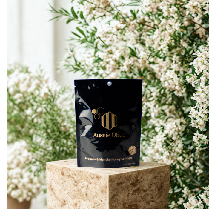 Aussie Qbee product packaging on a stone pedestal with a floral background