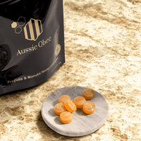 The Total Defense Kit | MGO 600+ Immunity Trio featuring Aussie Qbee Propolis & Manuka Honey lozenges on a marble plate.