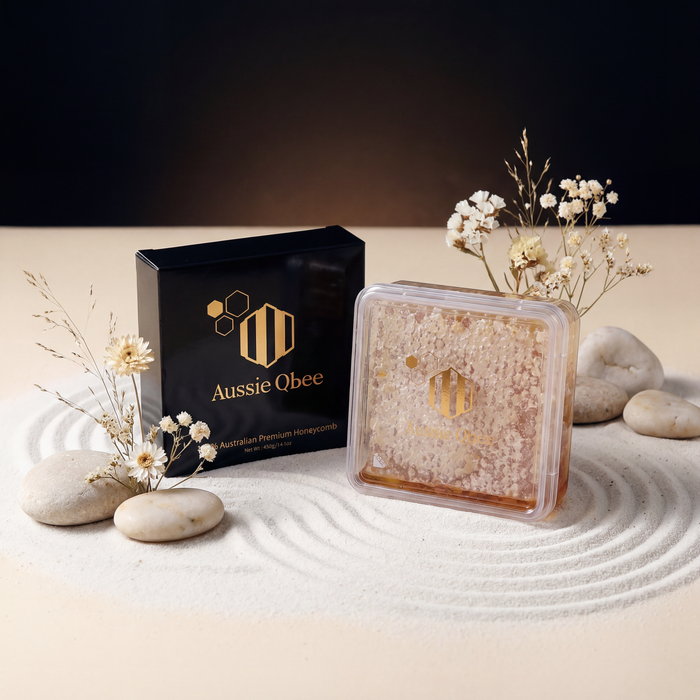 Aussie Qbee product packaging on a decorative setting with stones and flowers.
